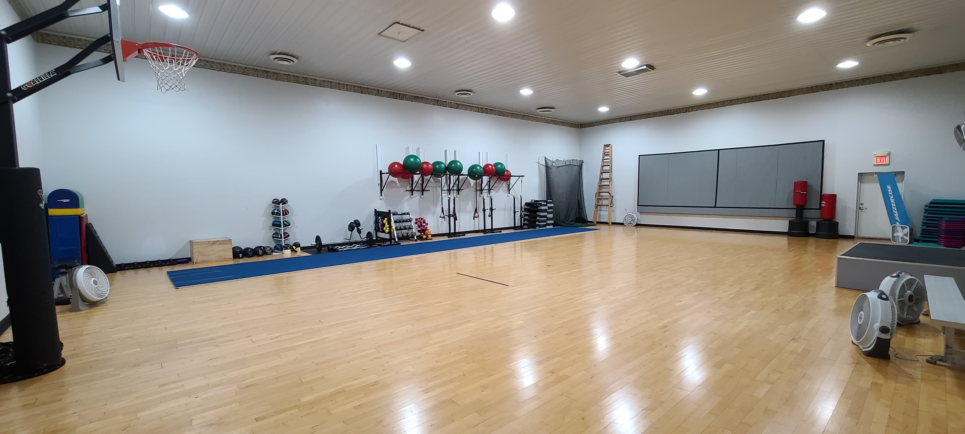 an open gym with a wall of exercise equipment